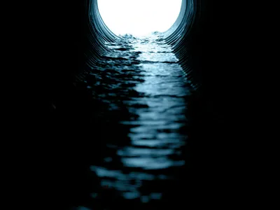 Camera view down the inside of a pipe with water flowing