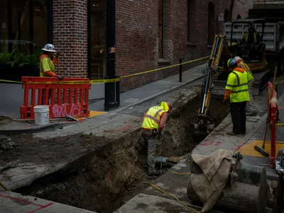 Crew working in an open excavation at a street