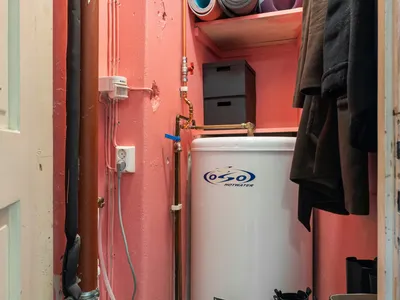 Tank water heater installed in a utility closet
