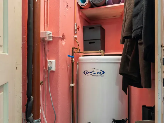 Tank water heater installed in a utility closet